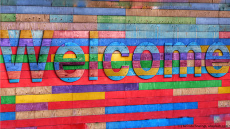 Bunter Schriftzug: "Welcome" auf Holzlattenwand